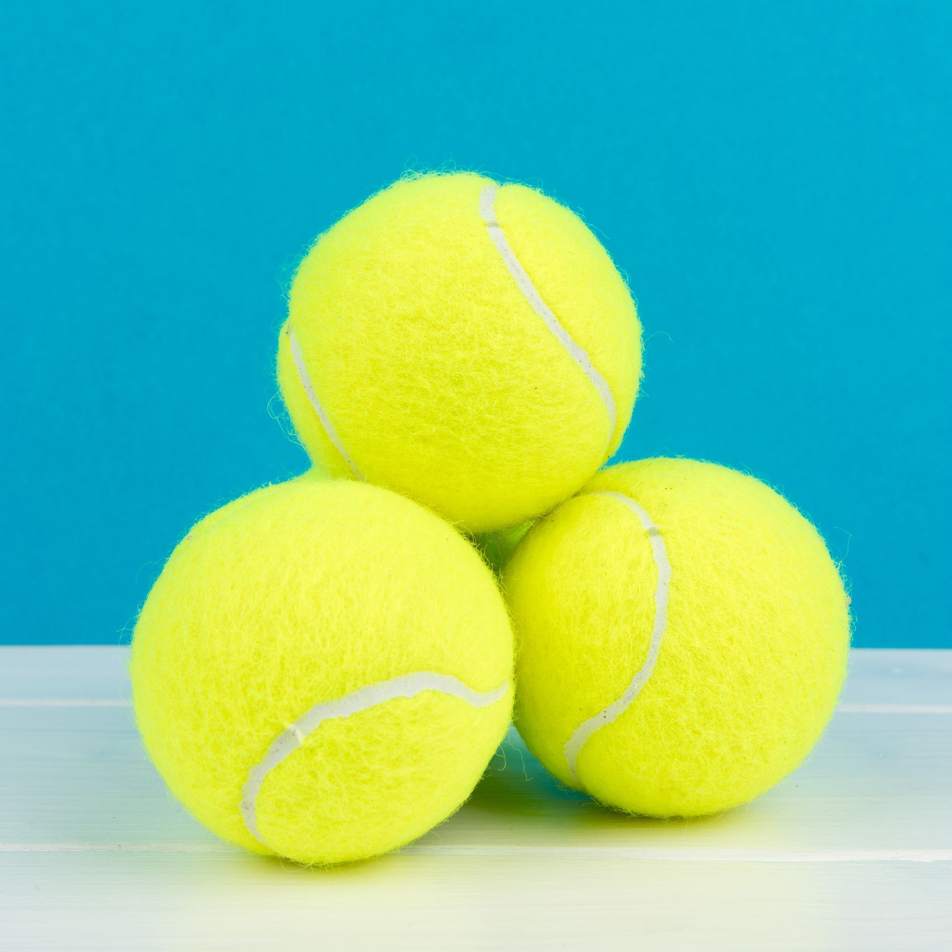 blue background with four tennis balls