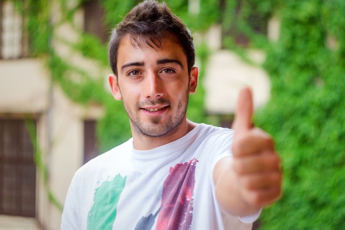 Portrait of a happy young man showing thumb up sign