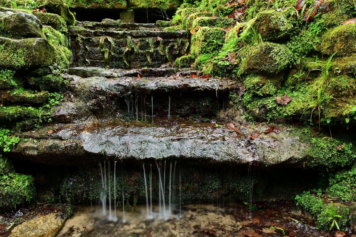 Long exposure of water trickling down stone steps in Ninesprings Park in Yeovil in Somerset