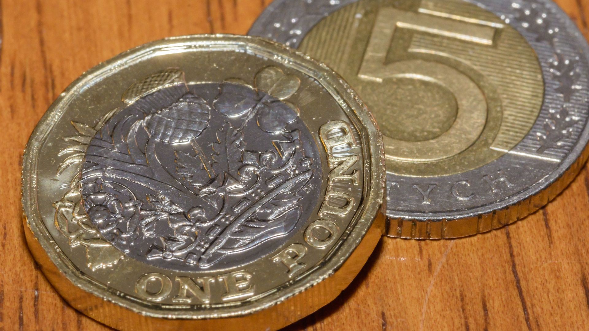 British Pound Coin on top of 5 Polish Zloty F, Shallow Depth of Field, Close up of Currency, GBP and PLN coin