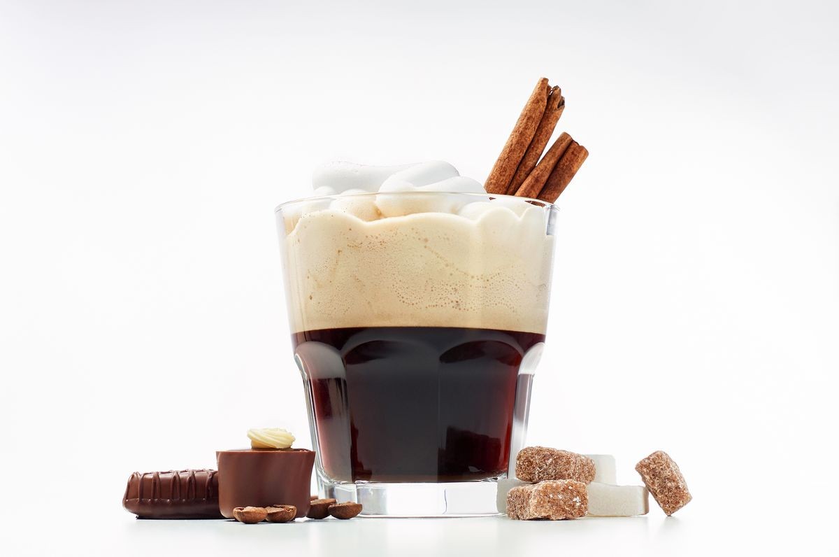 Espresso con panna or Vienna coffee. Two shots of espresso with whipped cream, cinnamon, sugar and chocolate candies. Close up view on white background