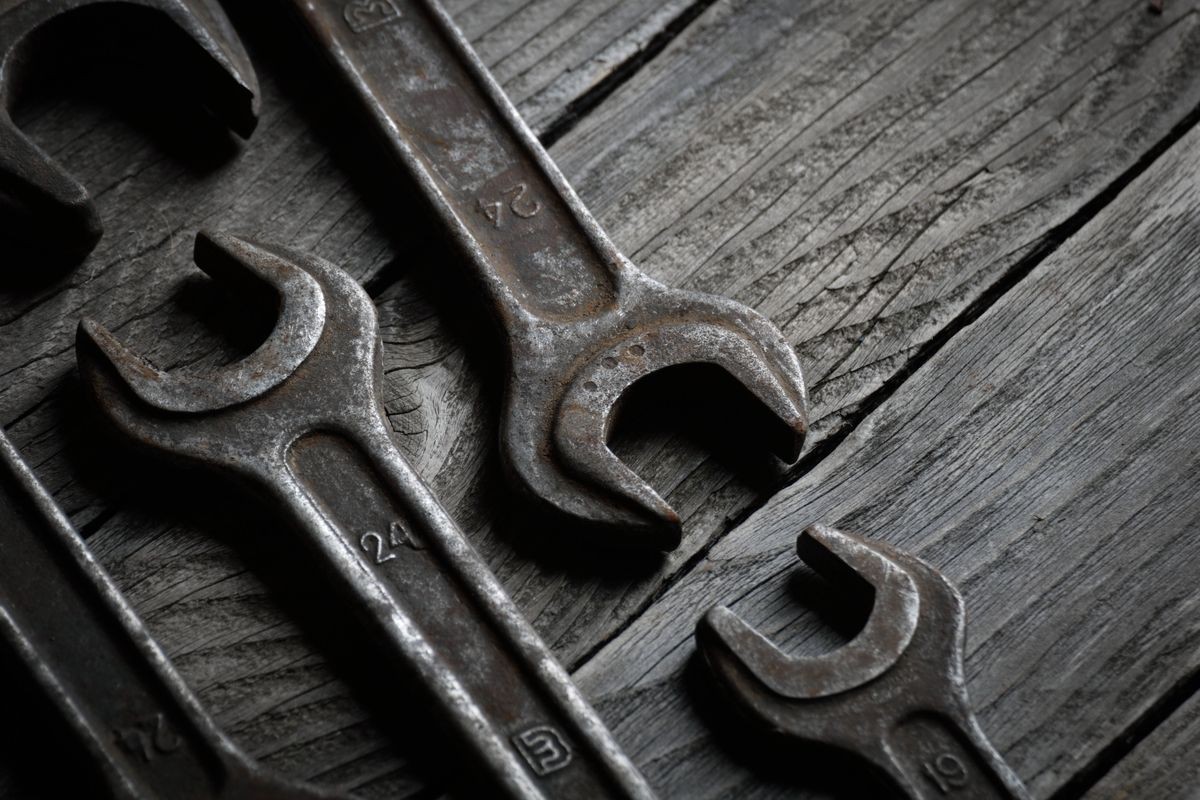 Dirty set of hand tools on a wooden background. Old rusty tools Sales tools for assembly workers. 
Old shop Old working. Vintage working tools (drill, saw, ruler and others) on wooden background