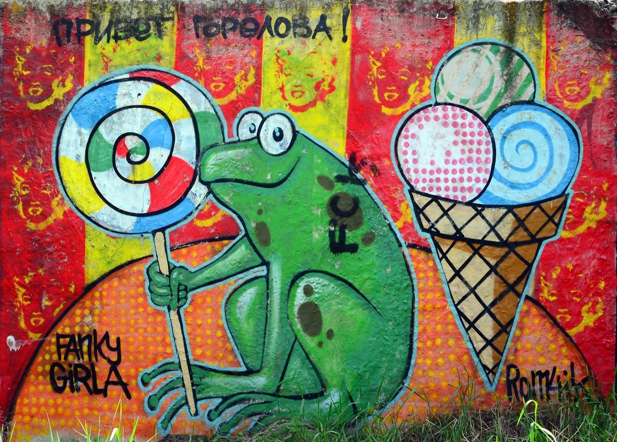 Street art. Abstract background image of a full completed graffiti painting with cartoon frog and lollipop.