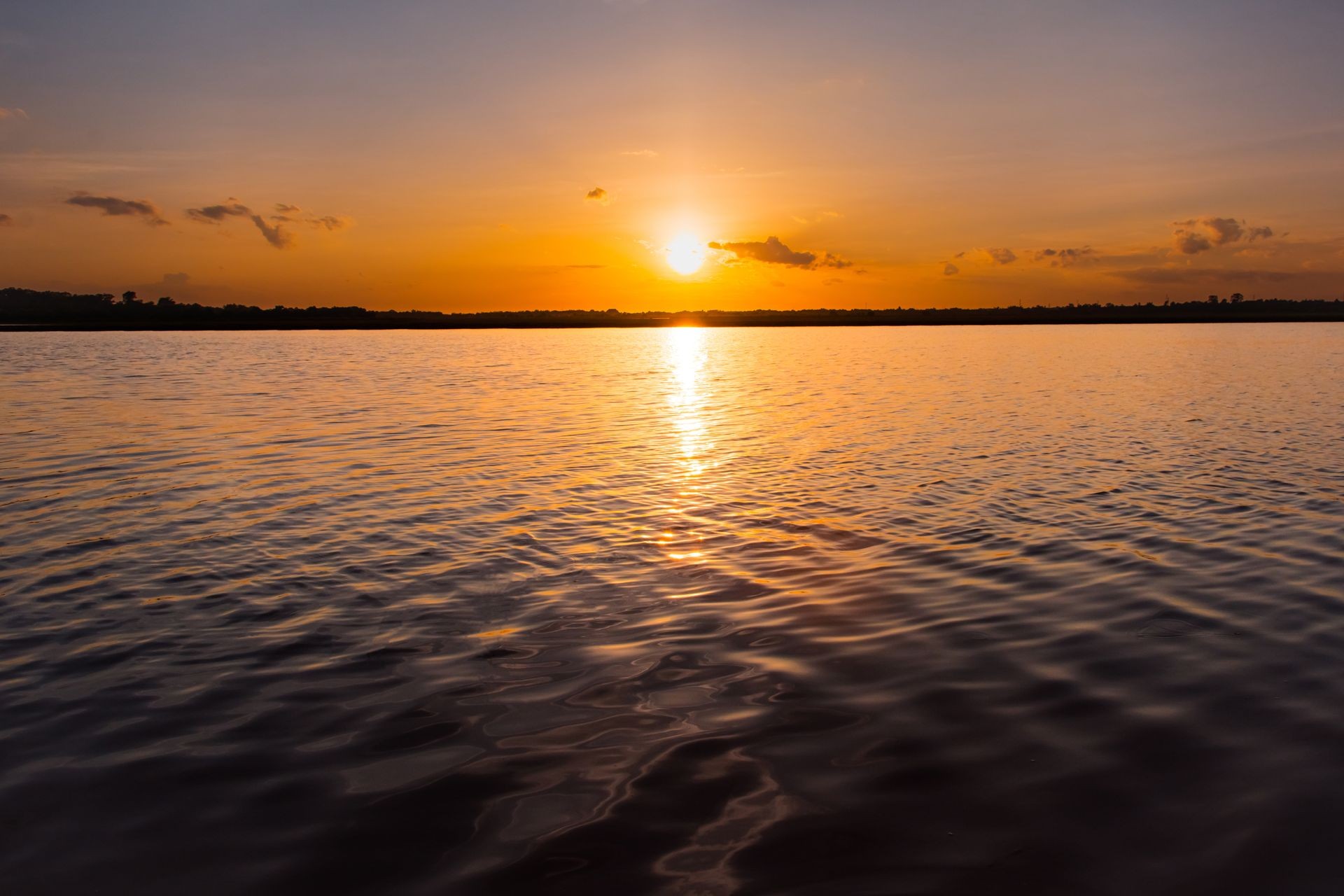 Sunset in the lake. beautiful sunset behind the clouds above the over lake landscape background. dramatic sky with cloud at sunset