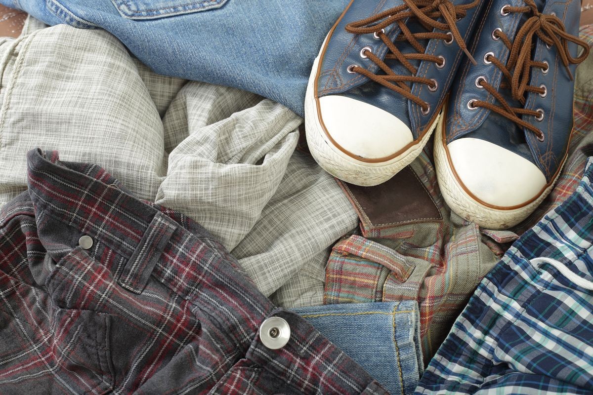 Clothes, shoes and accessories - Top view heap dirty colorful jeans background and gumshoes