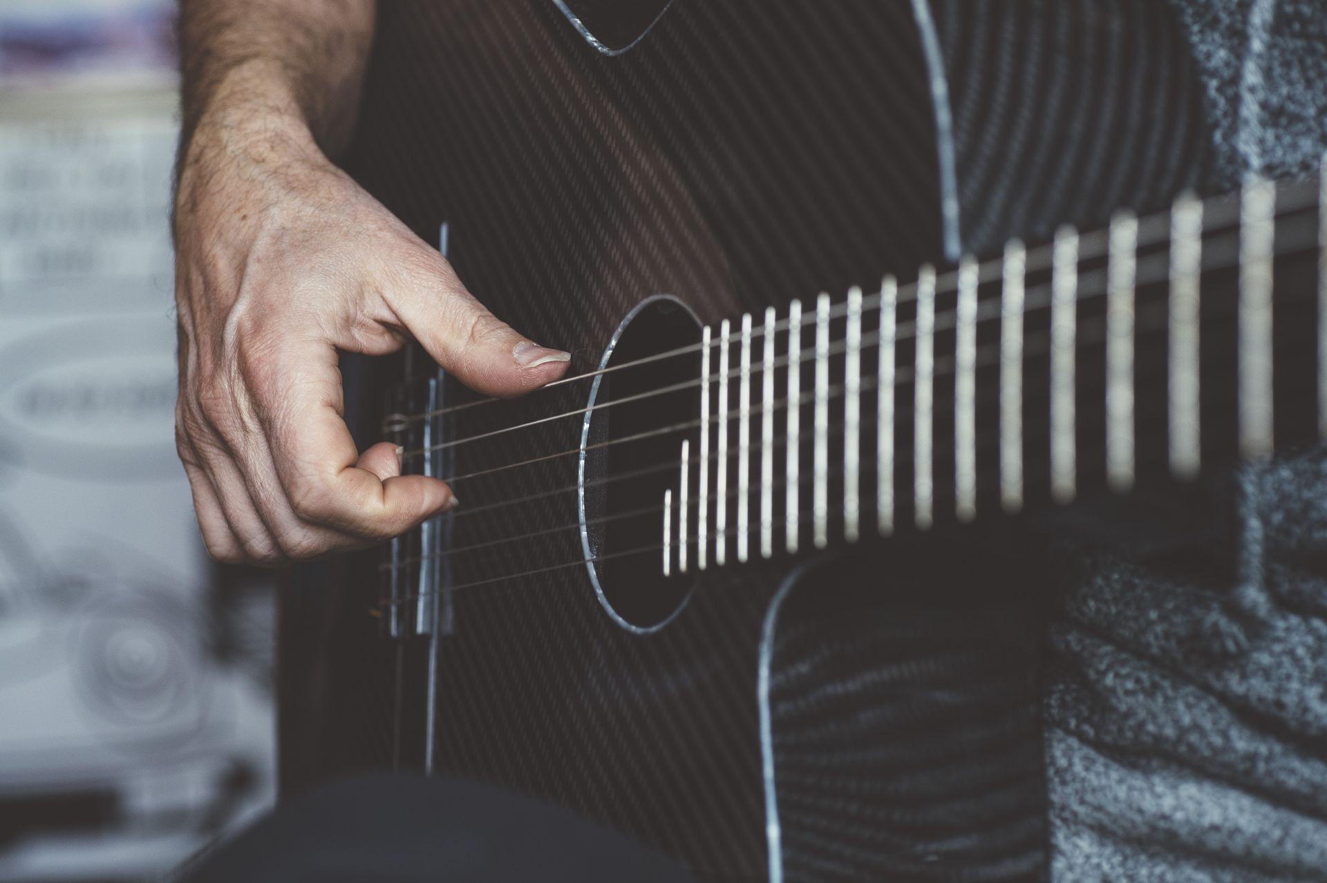 Elderly man playing carbon fiber guitar