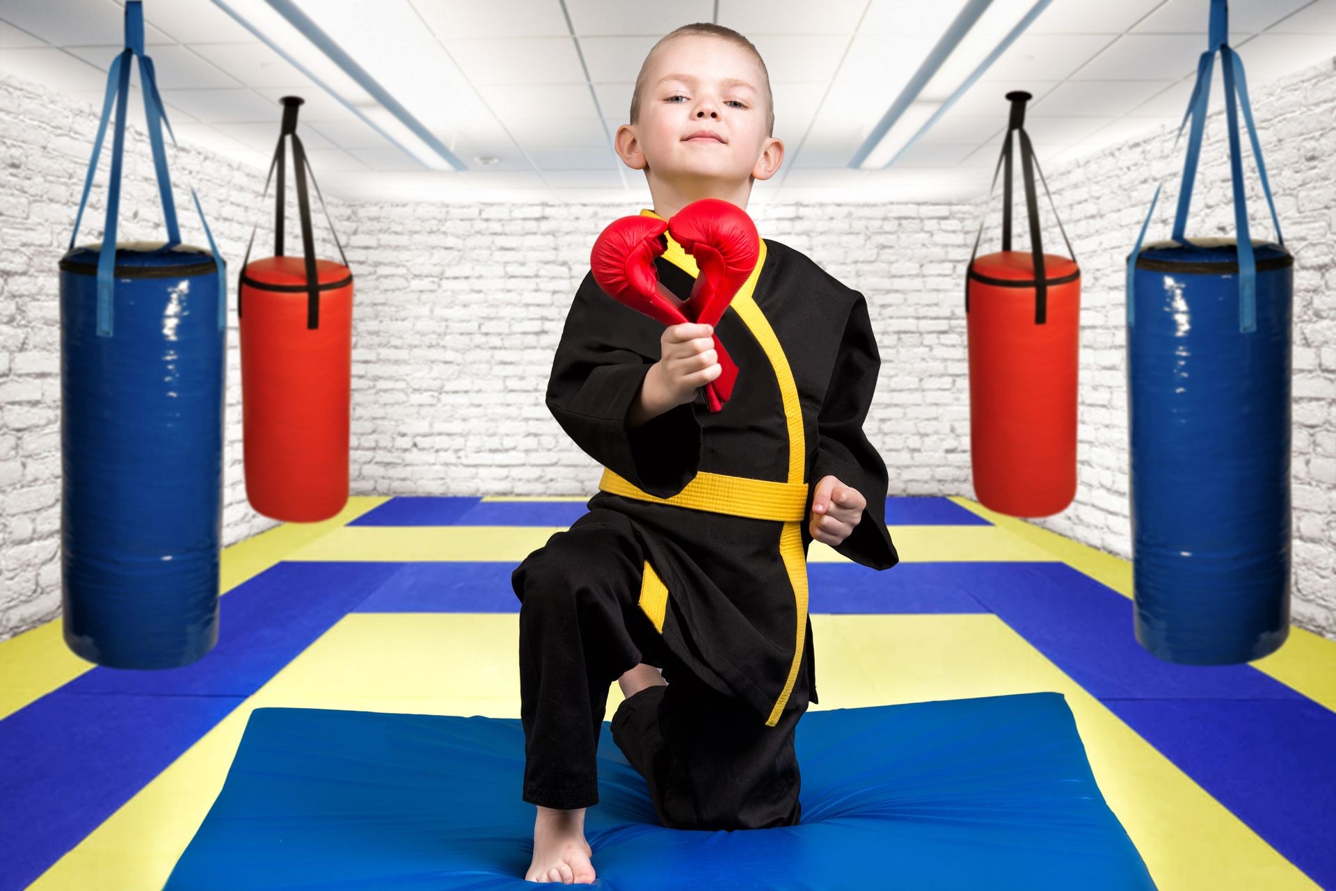 The boy athlete of karate gives a heart made of gloves ,a Declaration of love ,sympathy .Karate on the Mat in the gym.
