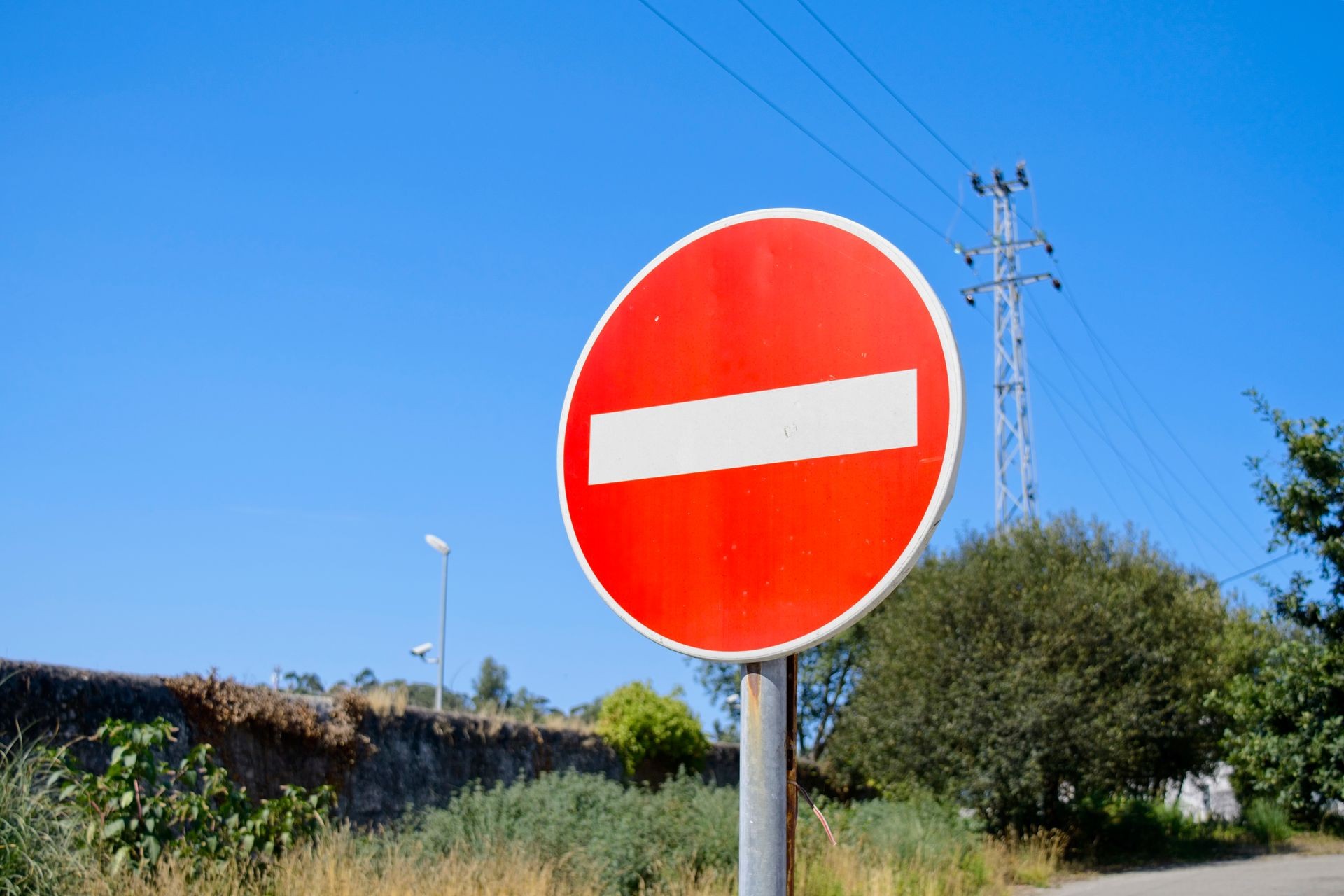 Red and white no entry traffic sign on a blue sky background