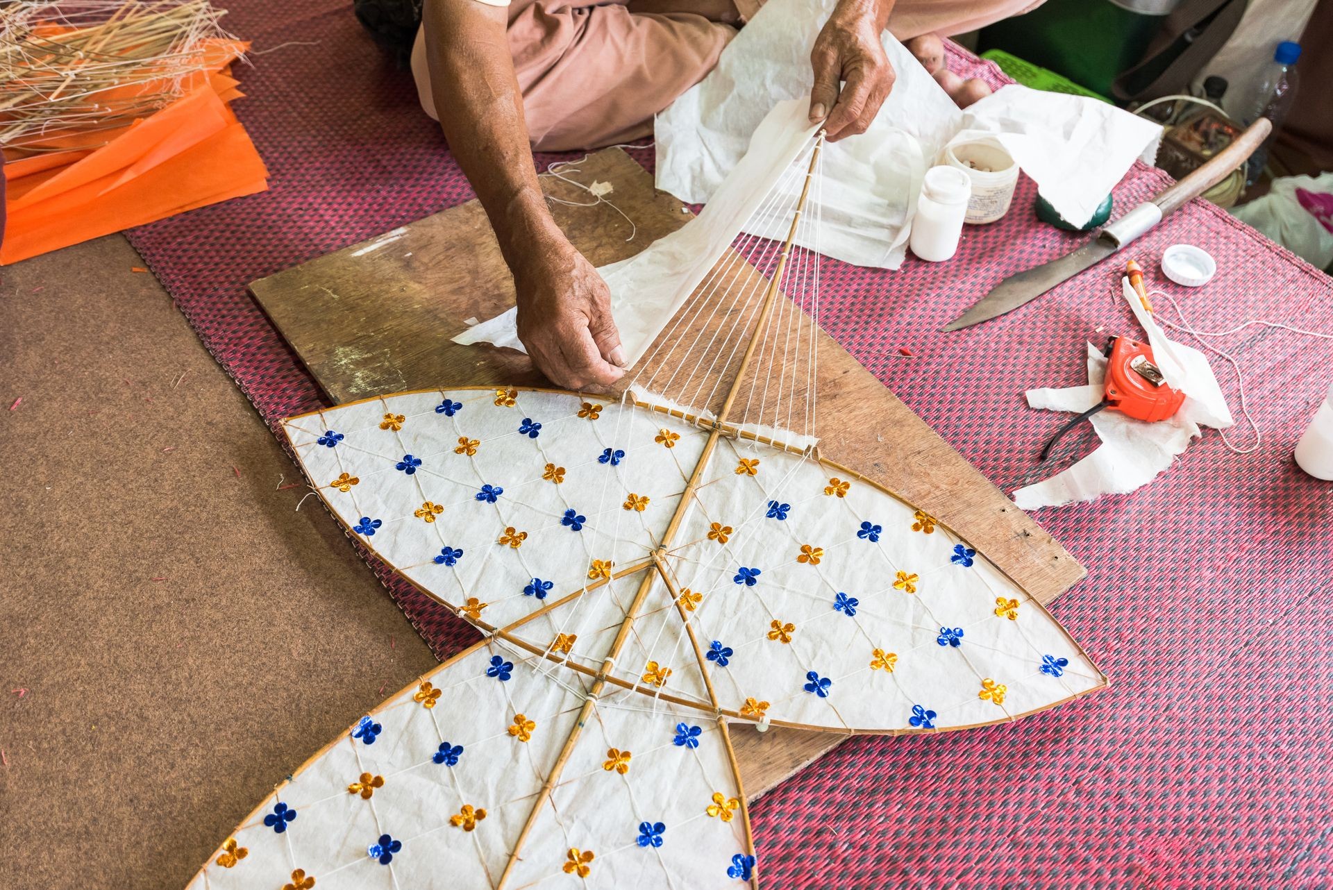 An old man making Thai traditional kite. Handmade kite decoration