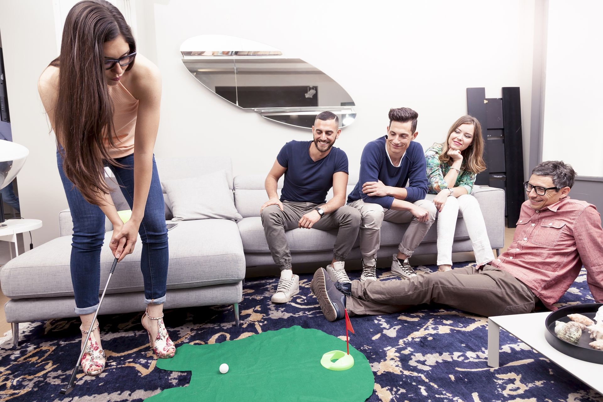 group of young adults have fun playing golf in the living room