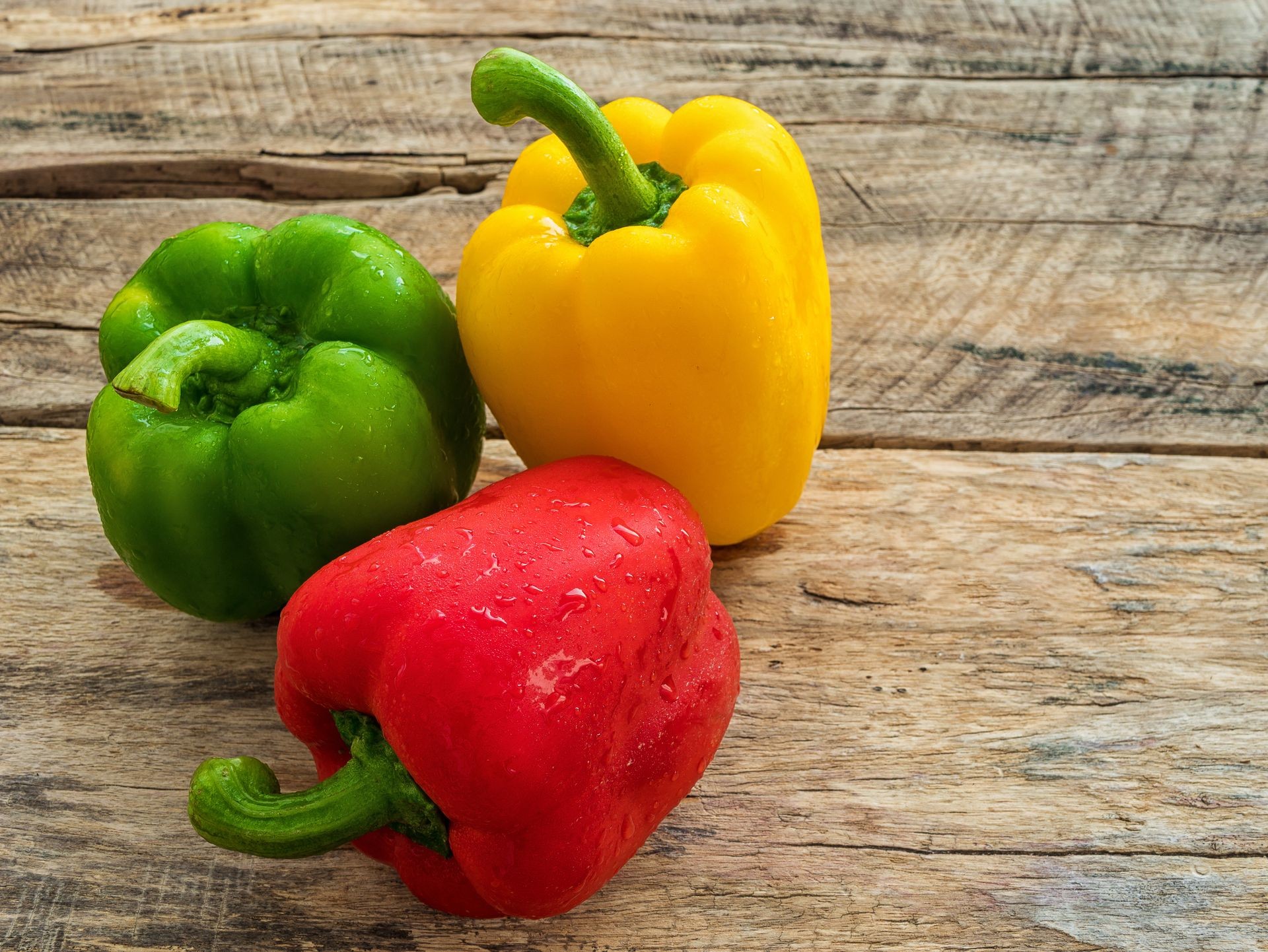 fresh green , red and yellow bell pepper on wooden background. spices vegetable