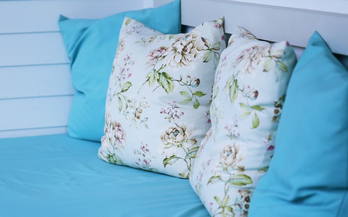 Blue and white fabric pillows on comfort sofa closeup blur background