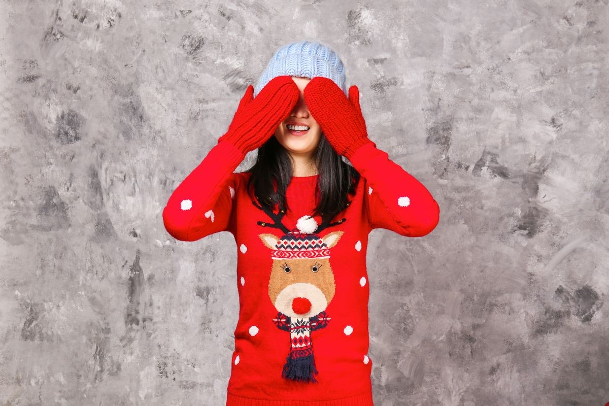 Beautiful smiling asian woman wearing knitted sweater celebrating Christmas. Attractive brunette casual female, new years eve. Ugly Christmas sweater concept. Background, copy space, close up portrait