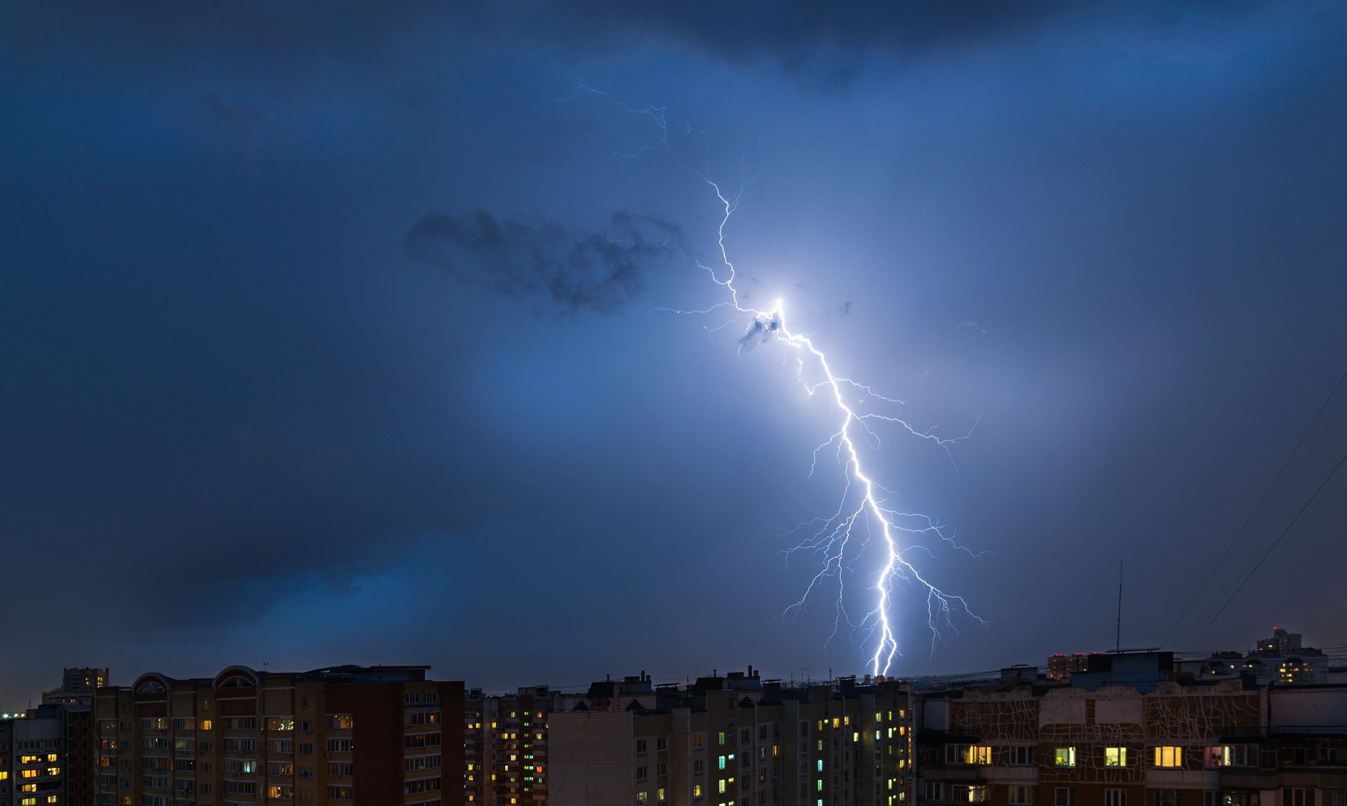 Storm clouds, heavy rain. Thunderstorm and lightning over the night city.