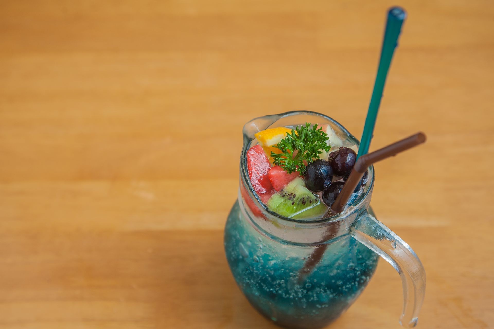 Water drinking Blue hawaii Soda Cocktail with ice and fruit on the jug glass for the hot day, Drinking in resturant 