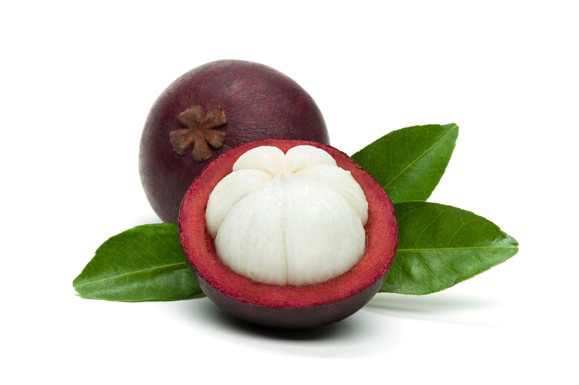 Mangosteen on white background, isolated whole exotic tropical fruit and another cut in half with green leaves, healthy food 