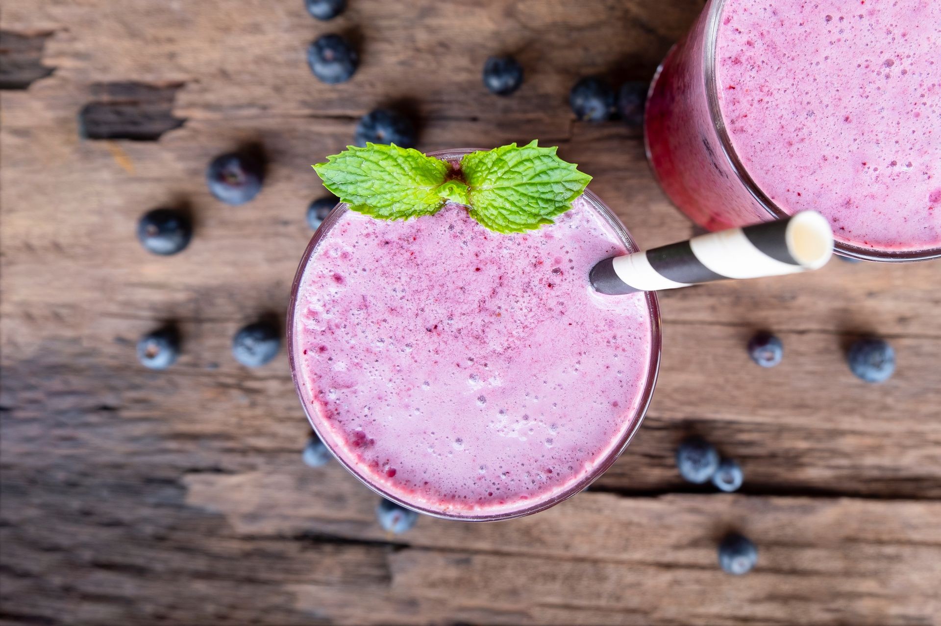 Blueberry smoothie purple colorful fruit juice milkshake blend beverage healthy high protein the taste yummy In glass,drink episode morning on a wooden background from the top view.