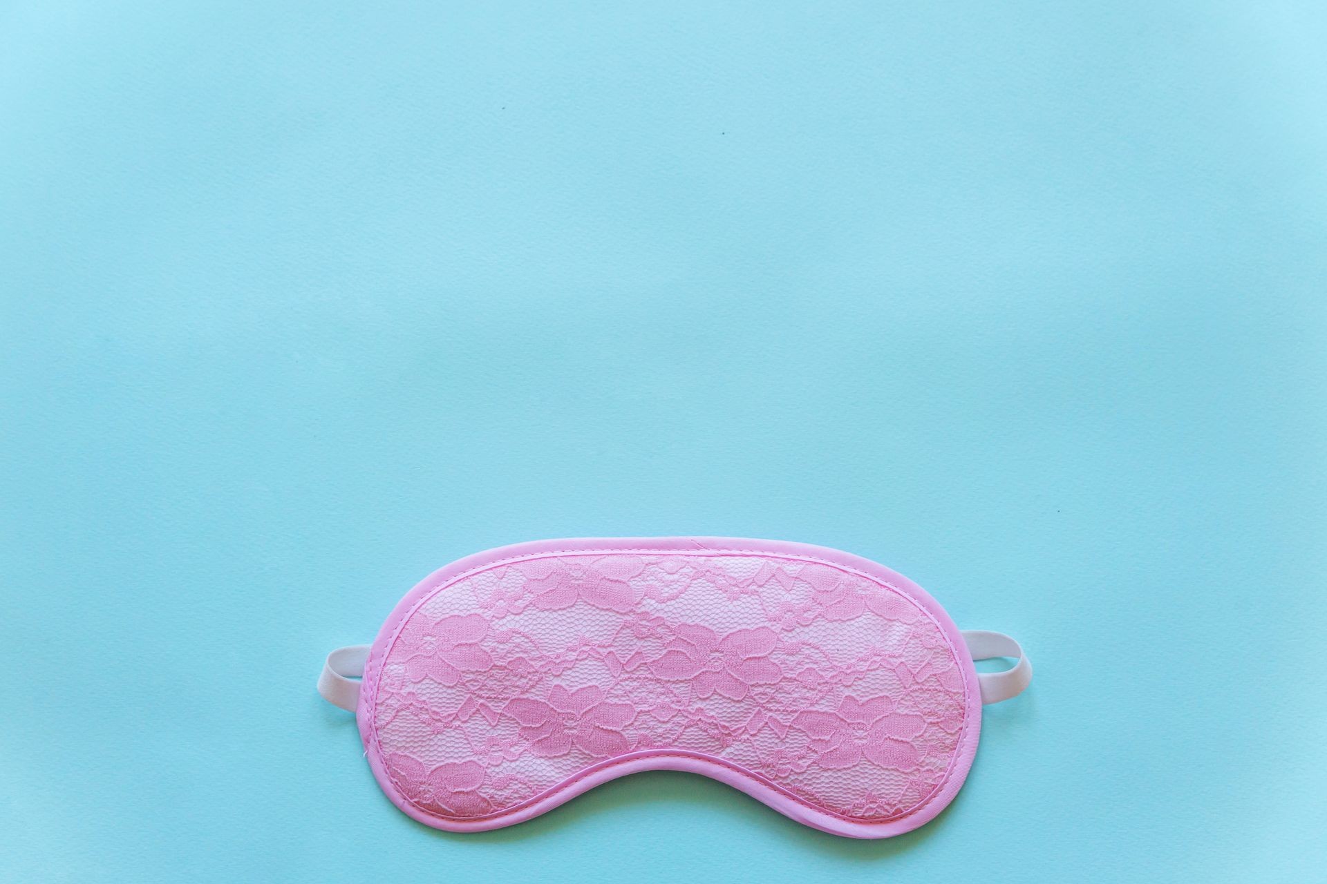 Sleeping eye mask, isolated on blue pastel colourful trendy background. Do not disturb me, let me sleep. Rest, good night, insomnia, relaxation, tired, travel concept