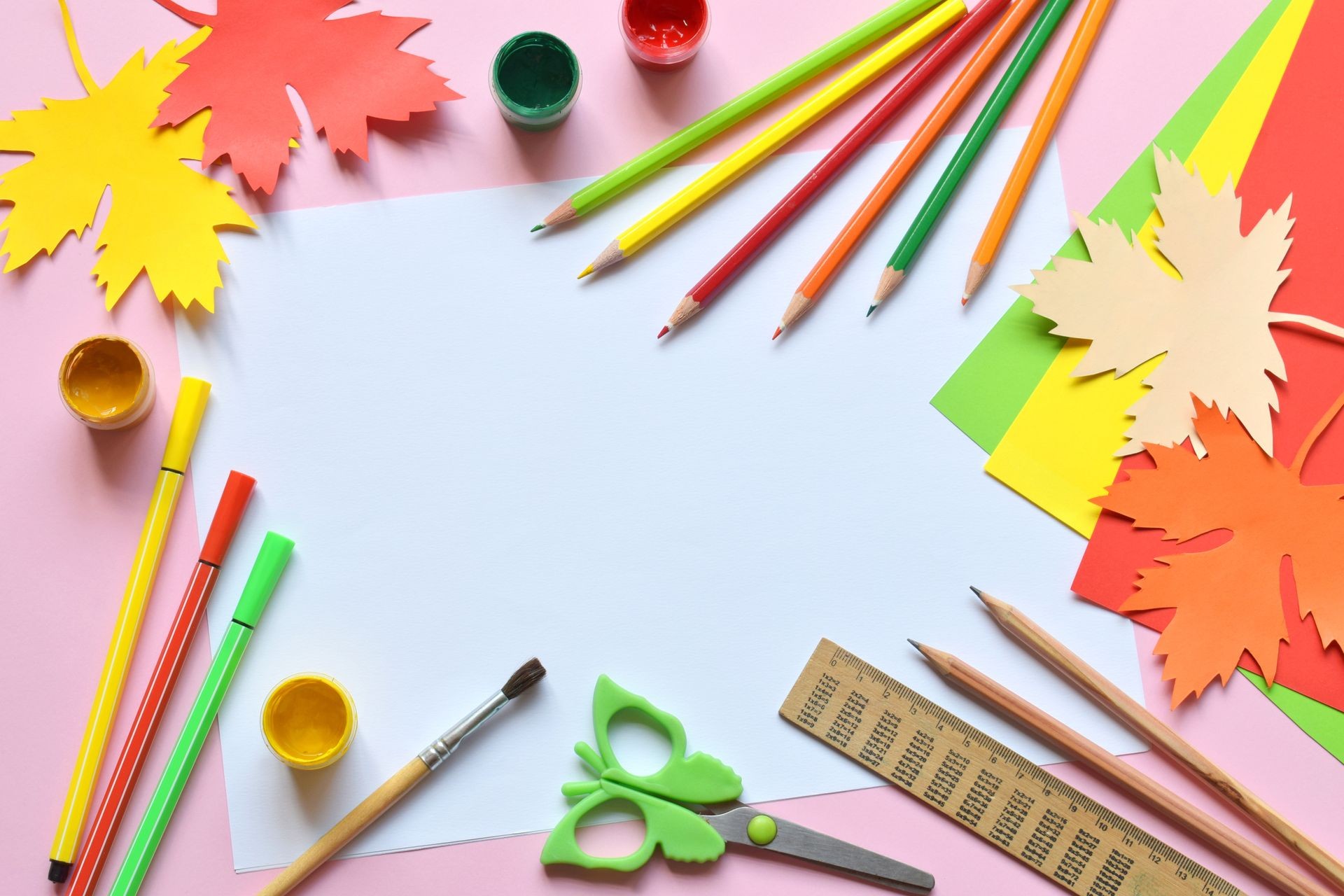 School accessories and supplies: pencils, paint, ruler, paper maple leaf, scissors on a light background. Back to school concept. Hello Autumn. Handmade crafts. Children's DIY. Flat lay. Copy space